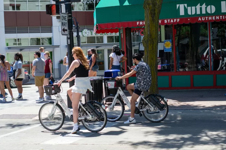 People riding electric bike share bikes in downtown Madison, Wisconsin